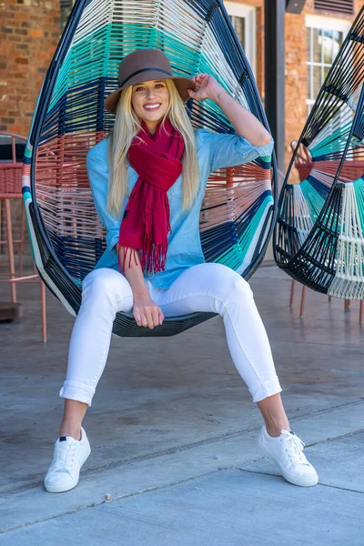 Sonbahar kıyafetleriyle dışarıda poz veren güzel bir sarışın manken.