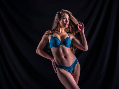 Stüdyo ortamında poz veren güzel bir melez iç çamaşırı modeli.