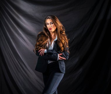 Stüdyo ortamında güzel bir karma ırk modeli iş elbisesi içinde poz verir.