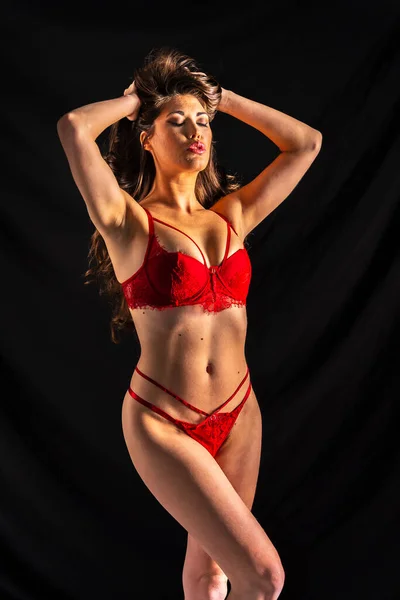 A beautiful mixed race lingerie model posing in a studio environment