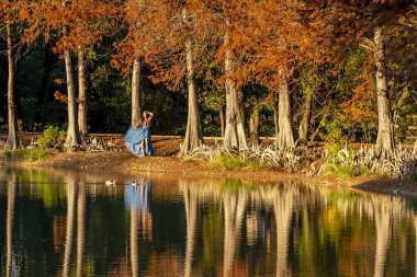 Muhteşem bir esmer model, sonbahar havasının tadını çıkarırken dışarıda poz veriyor.