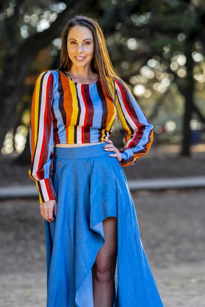 Muhteşem bir esmer model, sonbahar havasının tadını çıkarırken dışarıda poz veriyor.