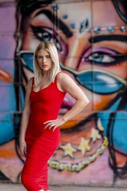 Sonbahar kıyafetleriyle dışarıda poz veren güzel bir sarışın manken.