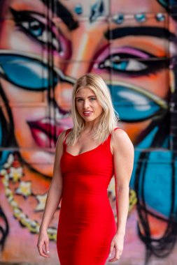 Sonbahar kıyafetleriyle dışarıda poz veren güzel bir sarışın manken.