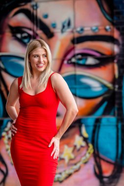 Sonbahar kıyafetleriyle dışarıda poz veren güzel bir sarışın manken.