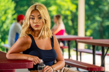 Muhteşem genç bir sarışın manken, Covid-19 salgını sırasında diğerlerinden güvenli bir mesafede kalarak dışarıda bir günün tadını çıkarıyor.