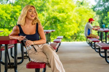 Muhteşem genç bir sarışın manken, Covid-19 salgını sırasında diğerlerinden güvenli bir mesafede kalarak dışarıda bir günün tadını çıkarıyor.