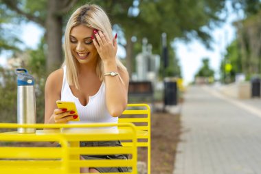 Sarışın bir model yaz gününün tadını çıkarırken dışarıda poz veriyor.