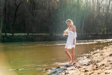 Sarışın bir model, açık havada bahar gününün tadını çıkarıyor. 