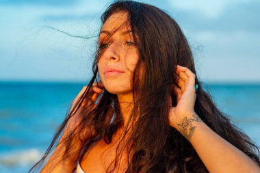 Güzel bir esmer model, Meksika, Merida yakınlarındaki Yucatan Yarımadası 'nda bir palmiye ağacının altında yumuşak ışığın tadını çıkarıyor.