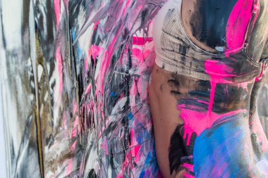 Çıplak bir kadın ev ortamında renkli boya ile boyanır.