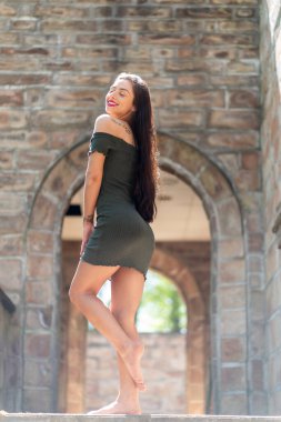 Muhteşem bir esmer model, açık havada bir bahar gününün tadını çıkarıyor. 