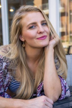 Sarışın bir manken, yaz günlerini dışarıda, parkta geçirmekten zevk alır.