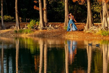 Muhteşem bir esmer model, sonbahar havasının tadını çıkarırken dışarıda poz veriyor.