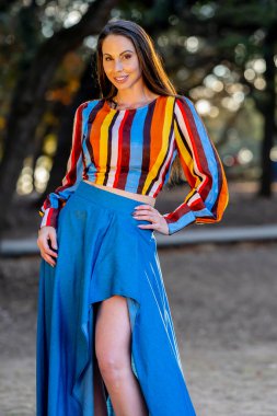 Muhteşem bir esmer model, sonbahar havasının tadını çıkarırken dışarıda poz veriyor.