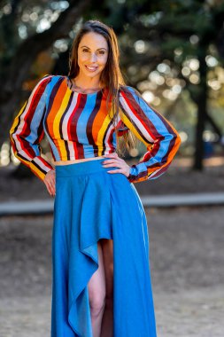 Muhteşem bir esmer model, sonbahar havasının tadını çıkarırken dışarıda poz veriyor.