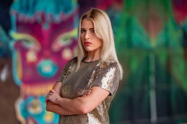 Sonbahar kıyafetleriyle dışarıda poz veren güzel bir sarışın manken.