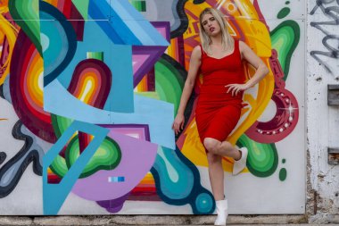 Sonbahar kıyafetleriyle dışarıda poz veren güzel bir sarışın manken.