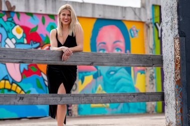 Sonbahar kıyafetleriyle dışarıda poz veren güzel bir sarışın manken.