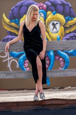 Sonbahar kıyafetleriyle dışarıda poz veren güzel bir sarışın manken.