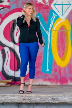 Sonbahar kıyafetleriyle dışarıda poz veren güzel bir sarışın manken.