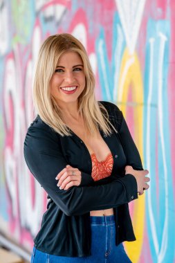 Sonbahar kıyafetleriyle dışarıda poz veren güzel bir sarışın manken.