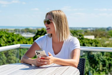 Sarışın bir model bahar kıyafetleriyle dışarıda poz veriyor.