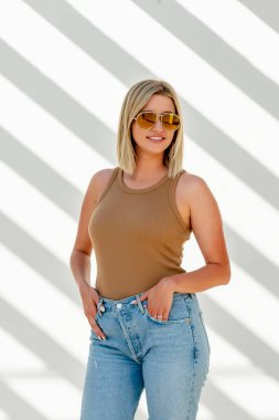 Sarışın bir model bahar kıyafetleriyle dışarıda poz veriyor.