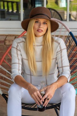 Sonbahar kıyafetleriyle dışarıda poz veren güzel bir sarışın manken.