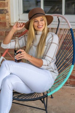 Sonbahar kıyafetleriyle dışarıda poz veren güzel bir sarışın manken.