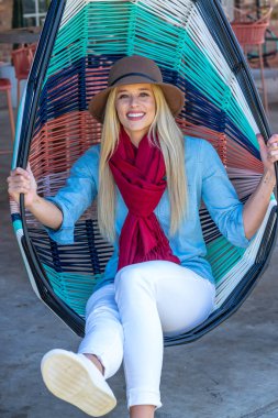 Sonbahar kıyafetleriyle dışarıda poz veren güzel bir sarışın manken.