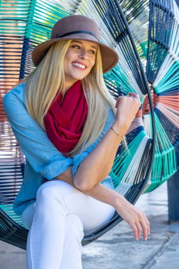 Sonbahar kıyafetleriyle dışarıda poz veren güzel bir sarışın manken.