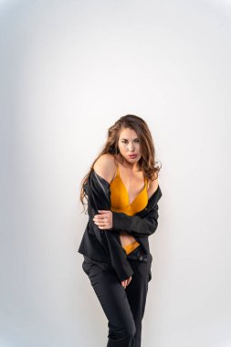 Stüdyo ortamında güzel bir karma ırk modeli iş elbisesi içinde poz verir.