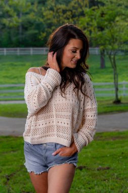 Muhteşem bir esmer model bahar havasının tadını çıkarırken dışarıda poz veriyor.