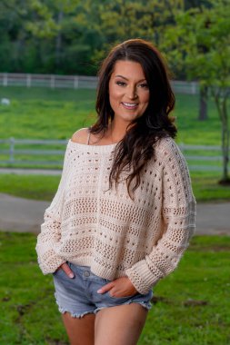 Muhteşem bir esmer model bahar havasının tadını çıkarırken dışarıda poz veriyor.