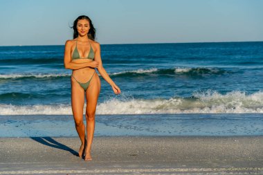 Güzel bir melez bikini modeli sahilde açık havanın tadını çıkarıyor.