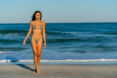 Güzel bir melez bikini modeli sahilde açık havanın tadını çıkarıyor.