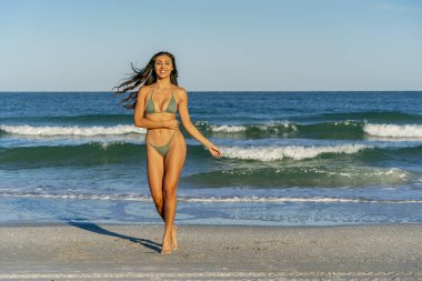 Güzel bir melez bikini modeli sahilde açık havanın tadını çıkarıyor.