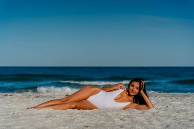 Güzel bir melez bikini modeli sahilde açık havanın tadını çıkarıyor.