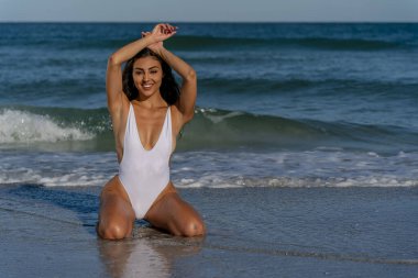 Güzel bir melez bikini modeli sahilde açık havanın tadını çıkarıyor.