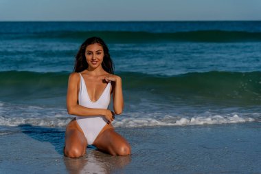Güzel bir melez bikini modeli sahilde açık havanın tadını çıkarıyor.