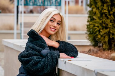 Sarışın bir model kış gününün tadını çıkarırken dışarıda poz veriyor.