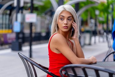 Sarışın bir model şehir ortamında poz veriyor.