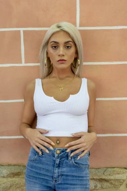 Sarışın bir model şehir ortamında poz veriyor.