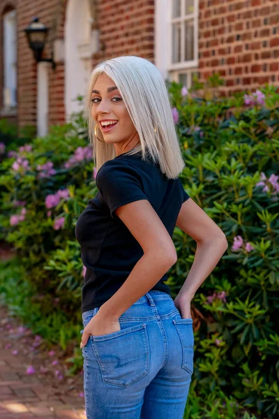 Sarışın bir model şehir ortamında poz veriyor.