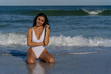 Güzel bir melez bikini modeli sahilde açık havanın tadını çıkarıyor.