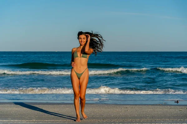 Güzel bir melez bikini modeli sahilde açık havanın tadını çıkarıyor.