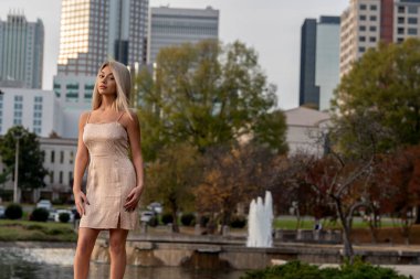 Genç ve güzel bir sarışın model, bir sonbahar gününün tadını çıkarırken dışarıda poz veriyor.