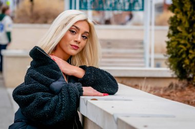 Sarışın bir model kış gününün tadını çıkarırken dışarıda poz veriyor.