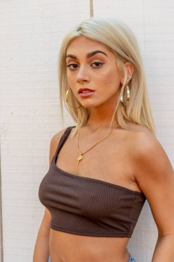 Sarışın bir model şehir ortamında poz veriyor.